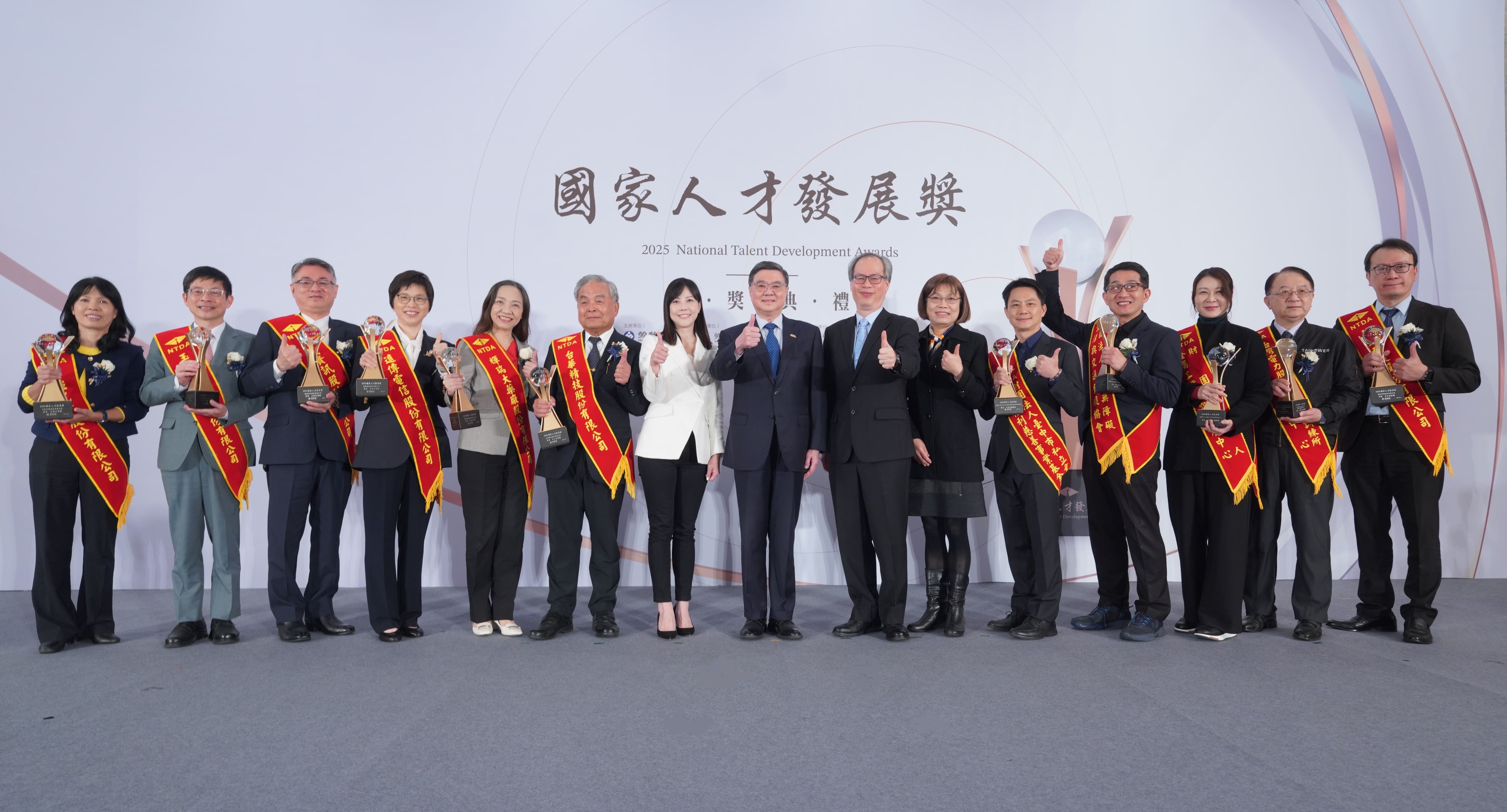 行政院院長卓榮泰(中)、行政院發言人李慧芝(左7)、勞動部常務次長陳明仁(右7)、勞動力發展署副署長施淑惠(右6)與大型企業、中小企業、機關(構)團體及非營利團體獎等11家得獎單位代表合影